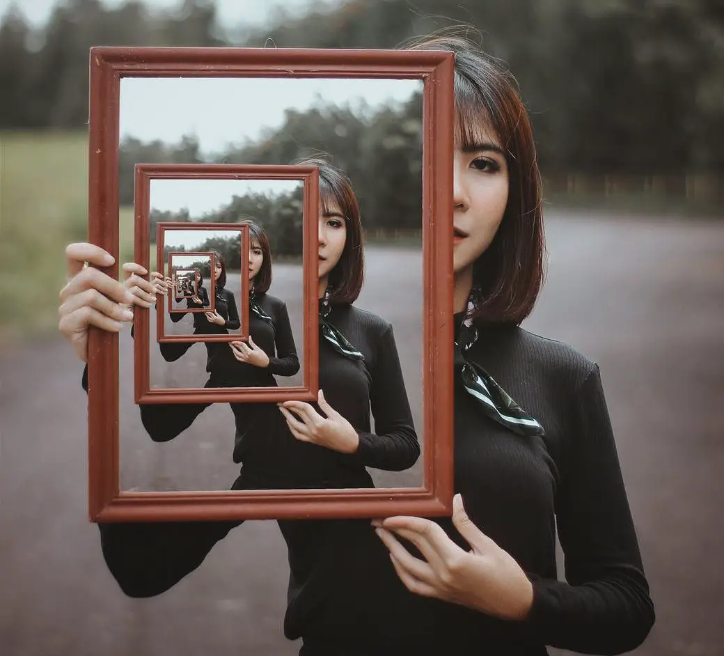 young woman with multiple reflection in mirror
